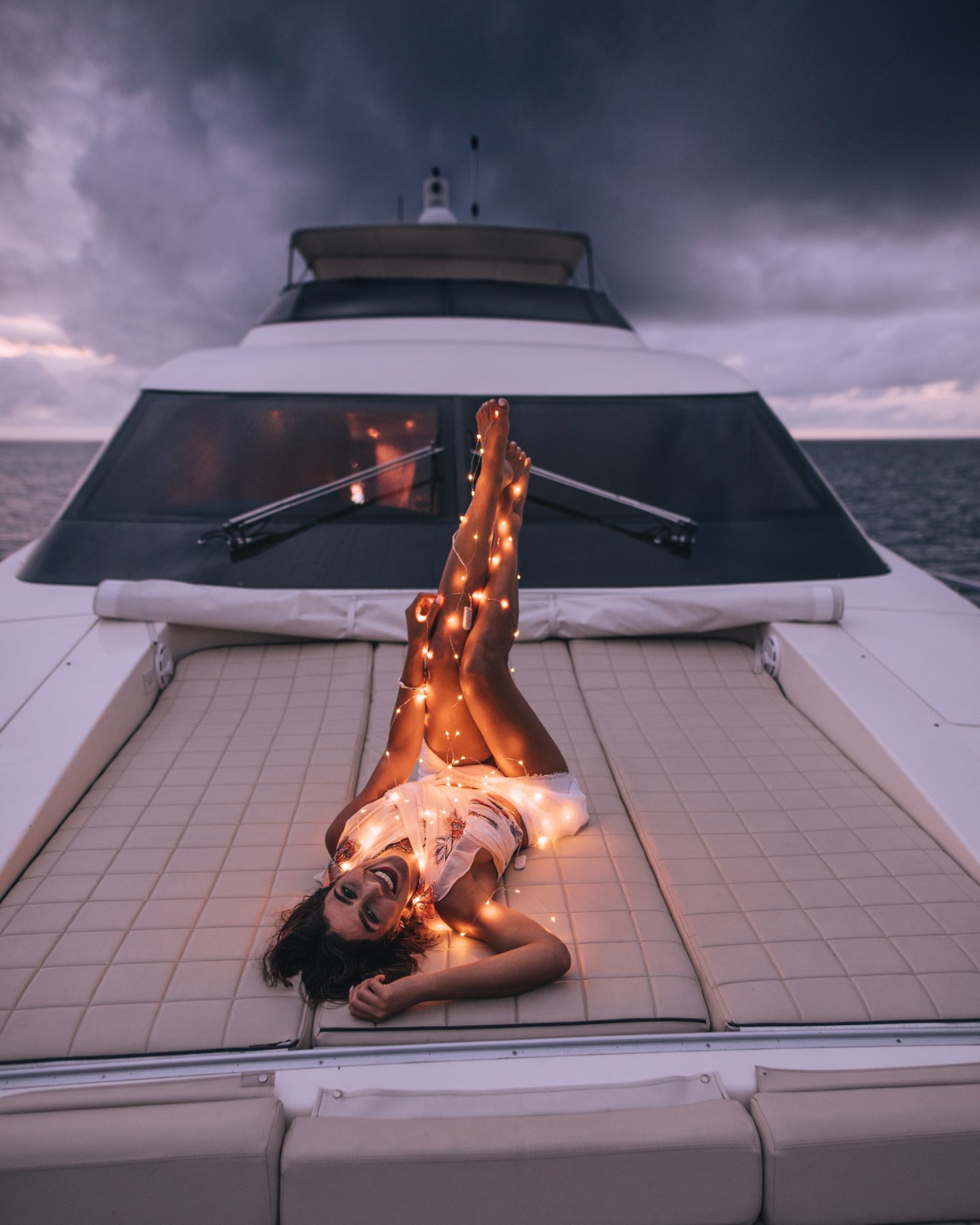 Woman with fairy lights on yacht in the Maldives - Nawaimaa Yacht
