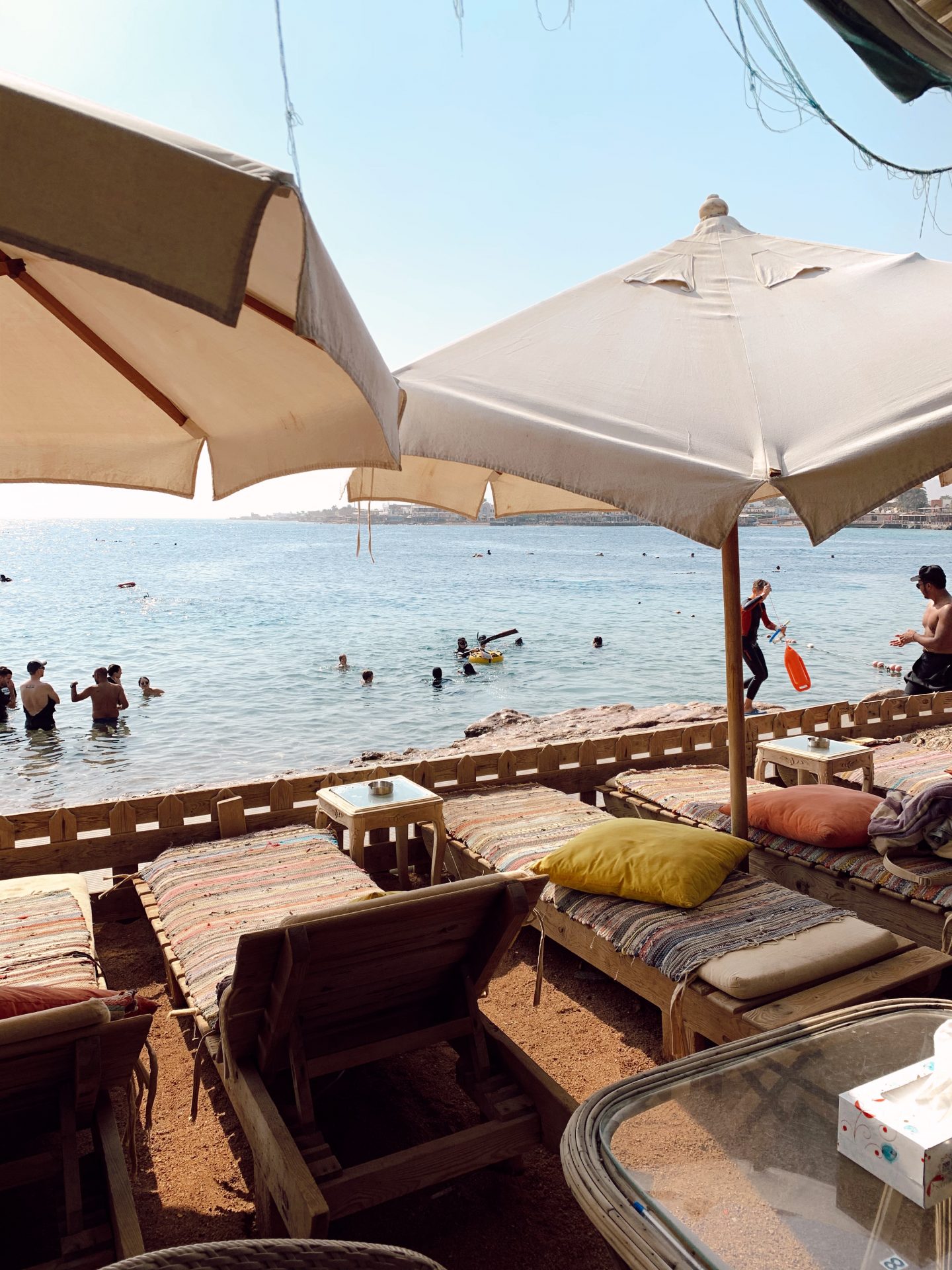 An area with lounge chairs and umbrellas on the beach in Dahab, Egypt by the Red Sea