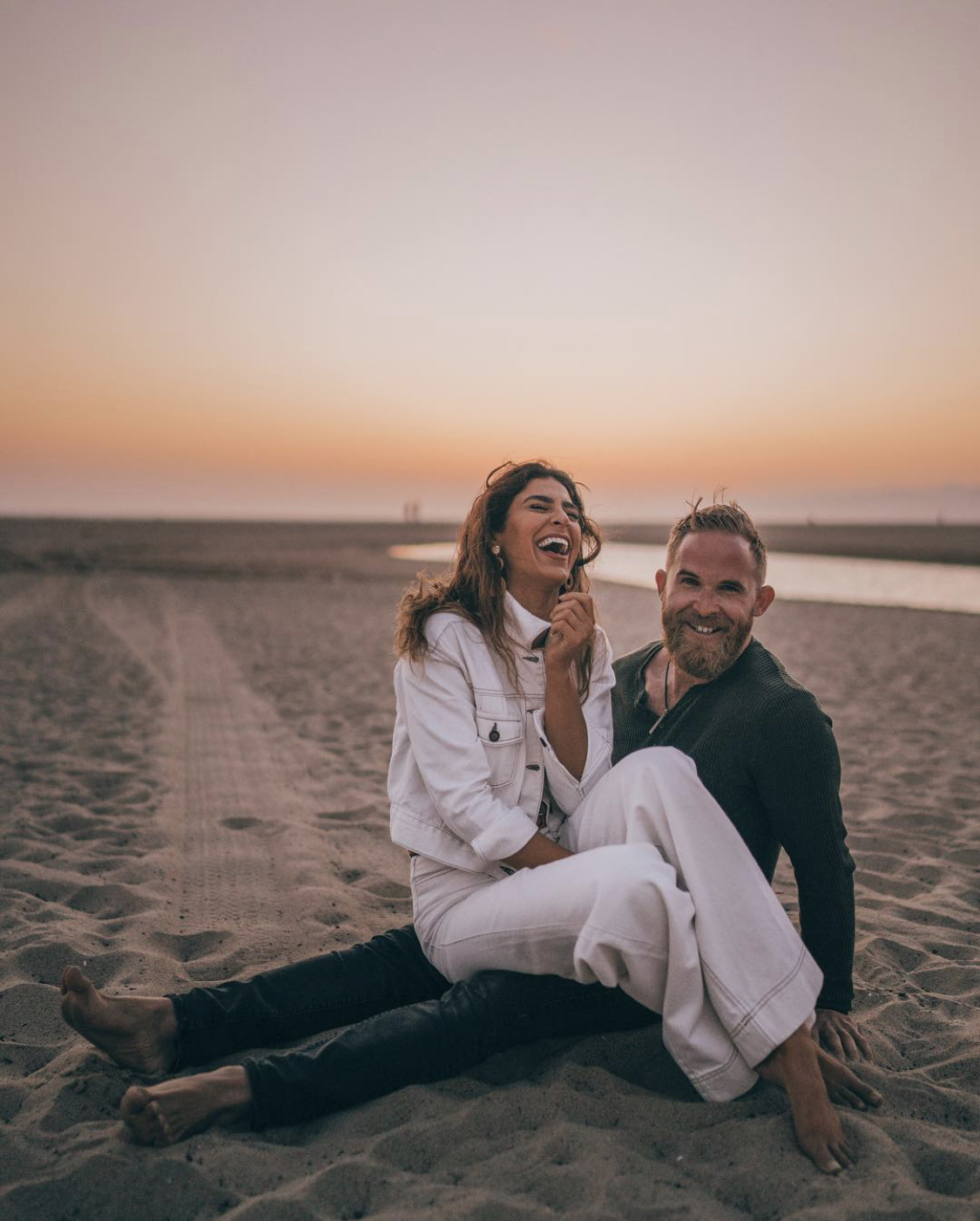 Couple laughing on the beach at sunset in Santa Monica California