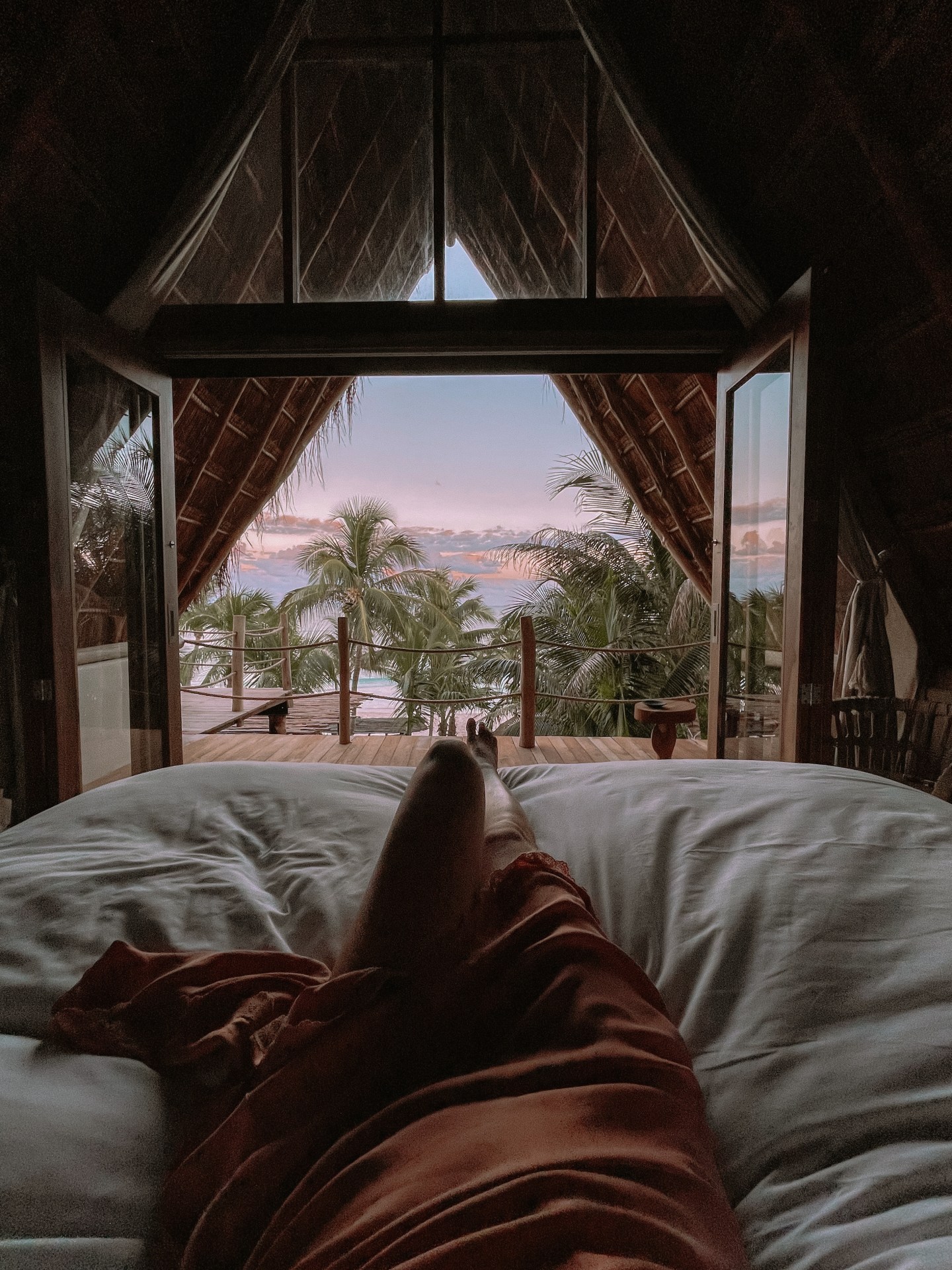 The sunset view laying in bed at La Valise hotel in Tulum Mexico