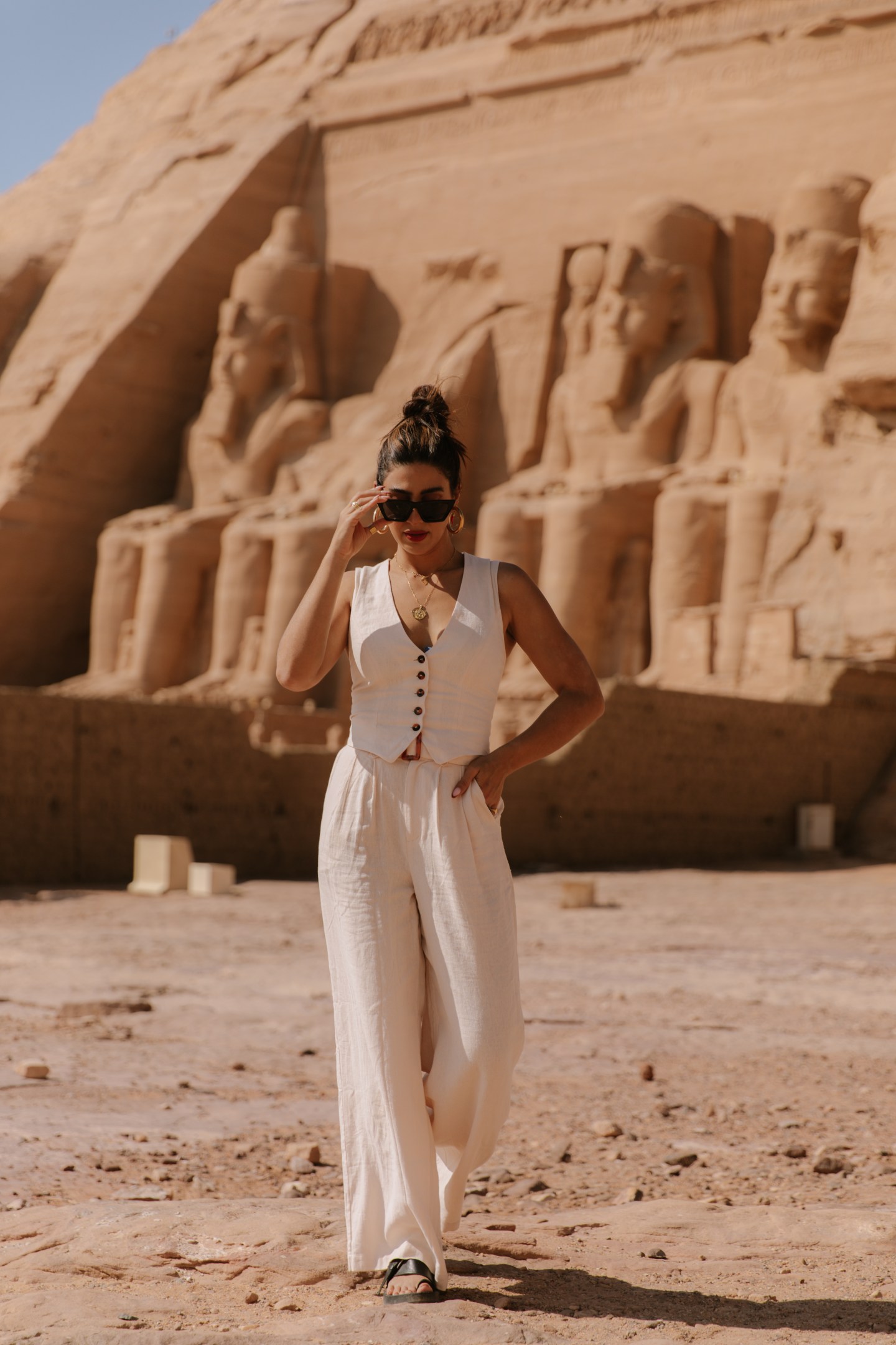 Girl wearing a cream pant suit exploring the ancient ruins of Abu Simbel, Egypt