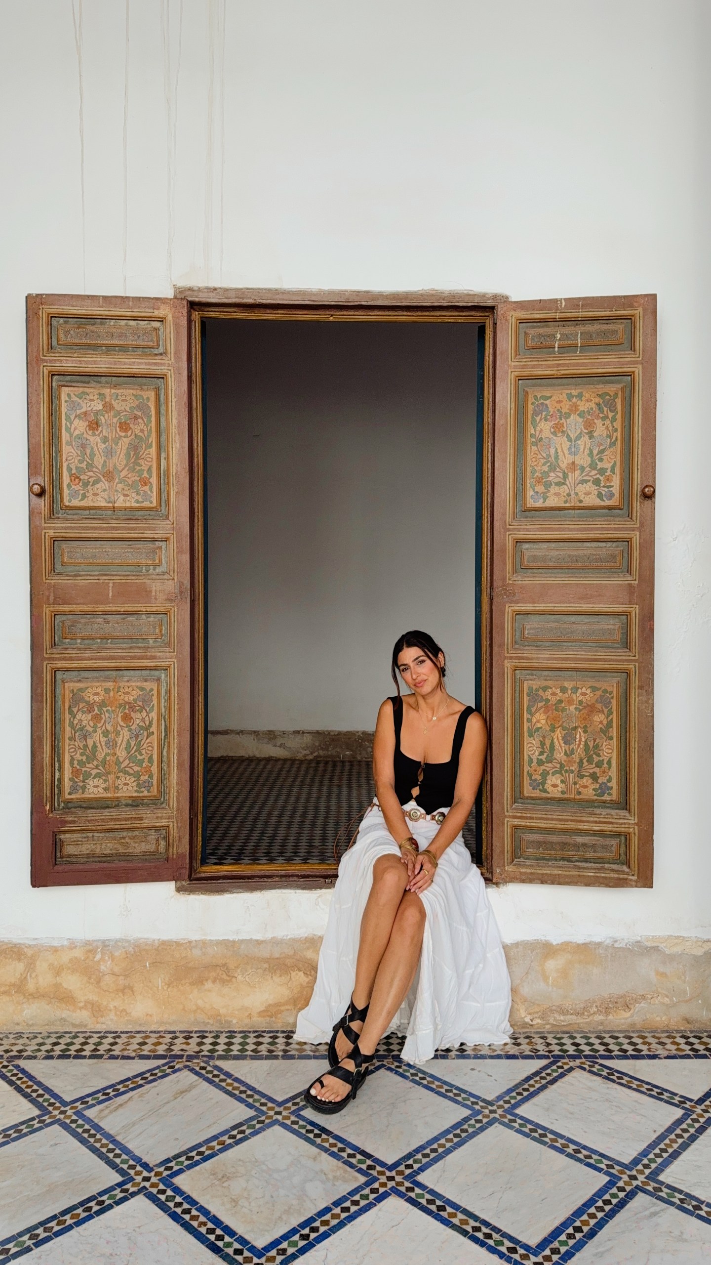 Girl sitting in a picture window in Marrakech's Bahia Palace