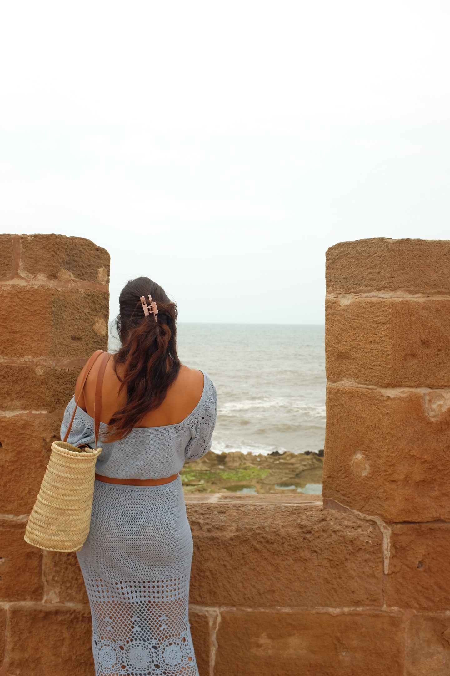 Girl standing looking out at the ocean from the Skala de la Ville